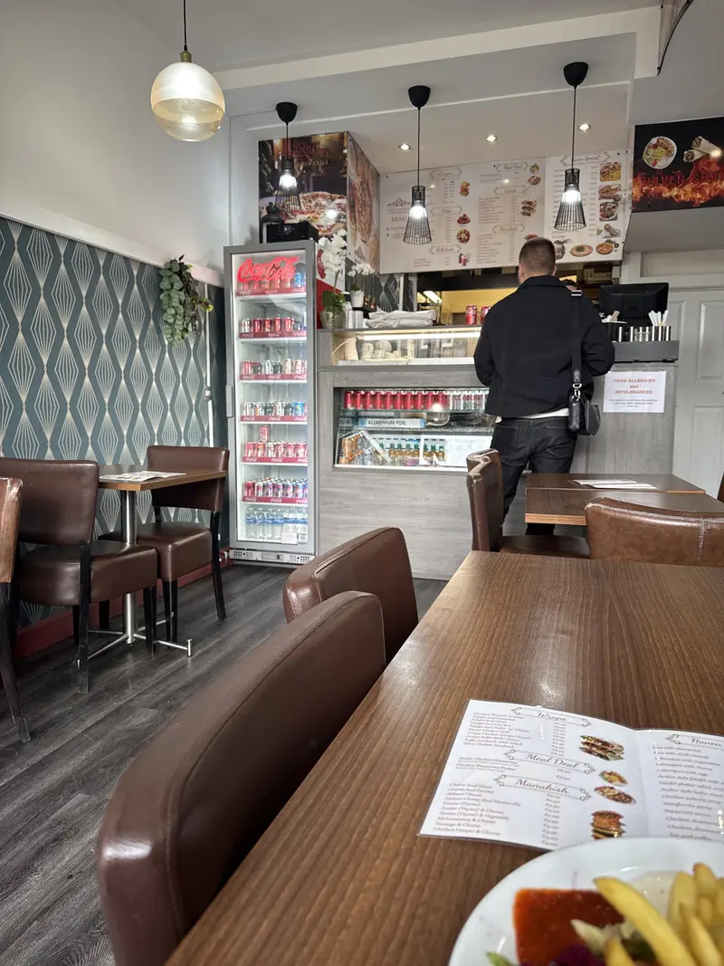 Inside Haven Shawarma — leather chairs, deco wallpaper and the counter